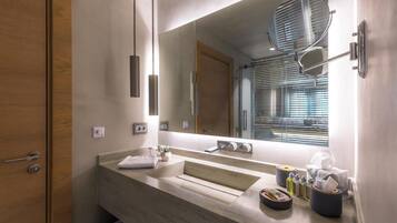 Un baño moderno con un espejo grande, un lavabo y una zona de ducha.