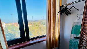 A room with a large window, a wooden door, and a wall-mounted drying rack. - Badualga Pink (San Teodoro)