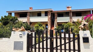 A two-story building with a stone facade, a gated entrance, and a number 35 sign. - Residence La Cinta 6 (San Teodoro)