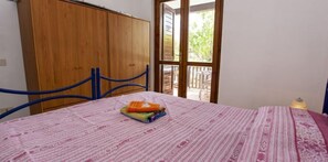 Cozy retreat with a single bed, wooden wardrobe, and large window offering a view of the outdoors.