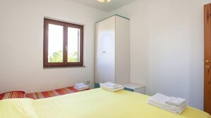 A small, bright room with a bed, a window, and a wardrobe. - Residence La Cinta 2 (San Teodoro)