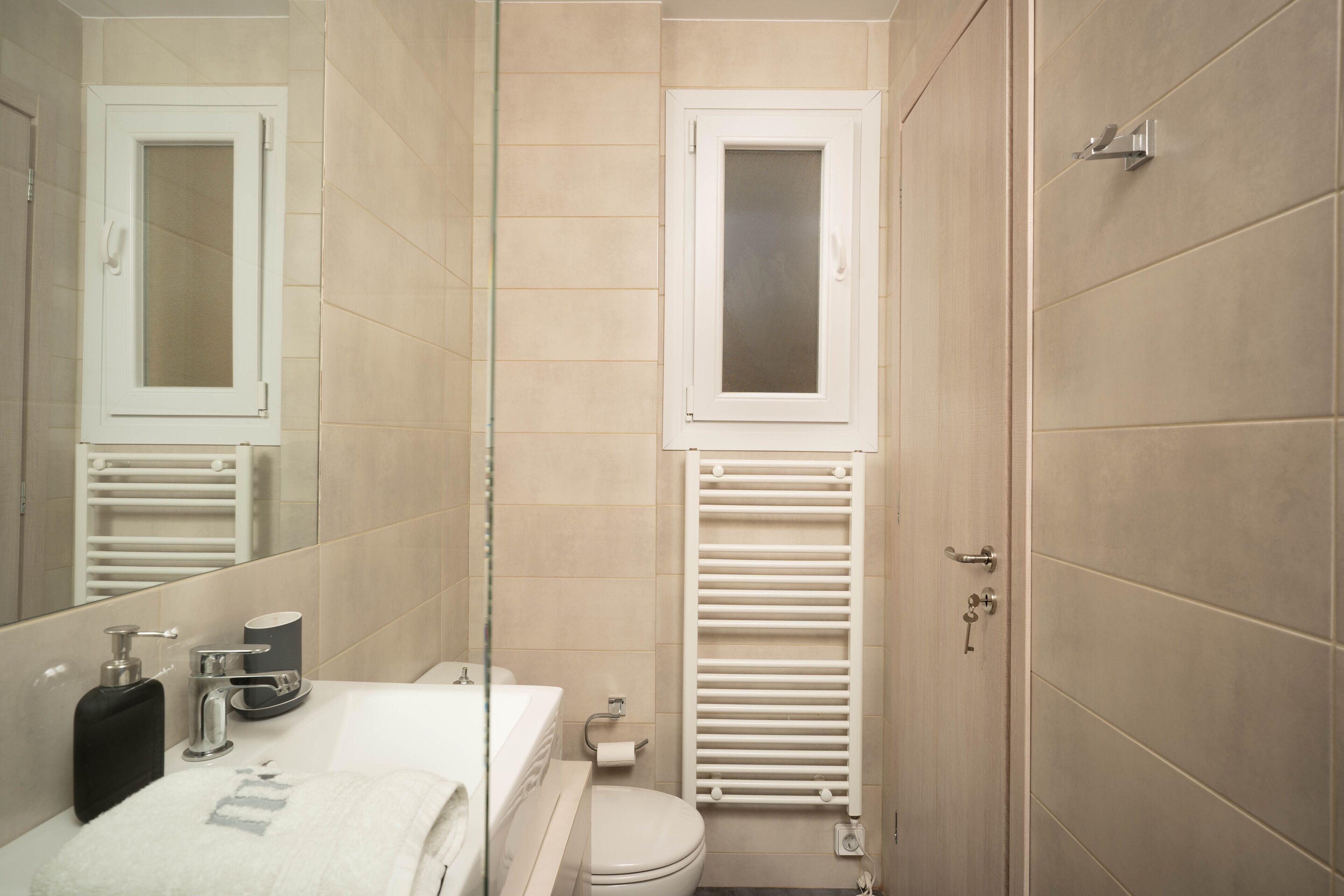Une salle de bain moderne avec des toilettes, un lavabo et un miroir.