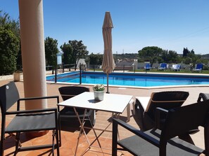 Un espace aménagé au bord de la piscine, comprenant une piscine, des chaises et une table.