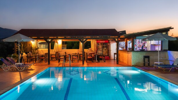 A swimming pool with lounge chairs and a bar area. - Sisi Breeze Hotel (Agios Nikolaos)