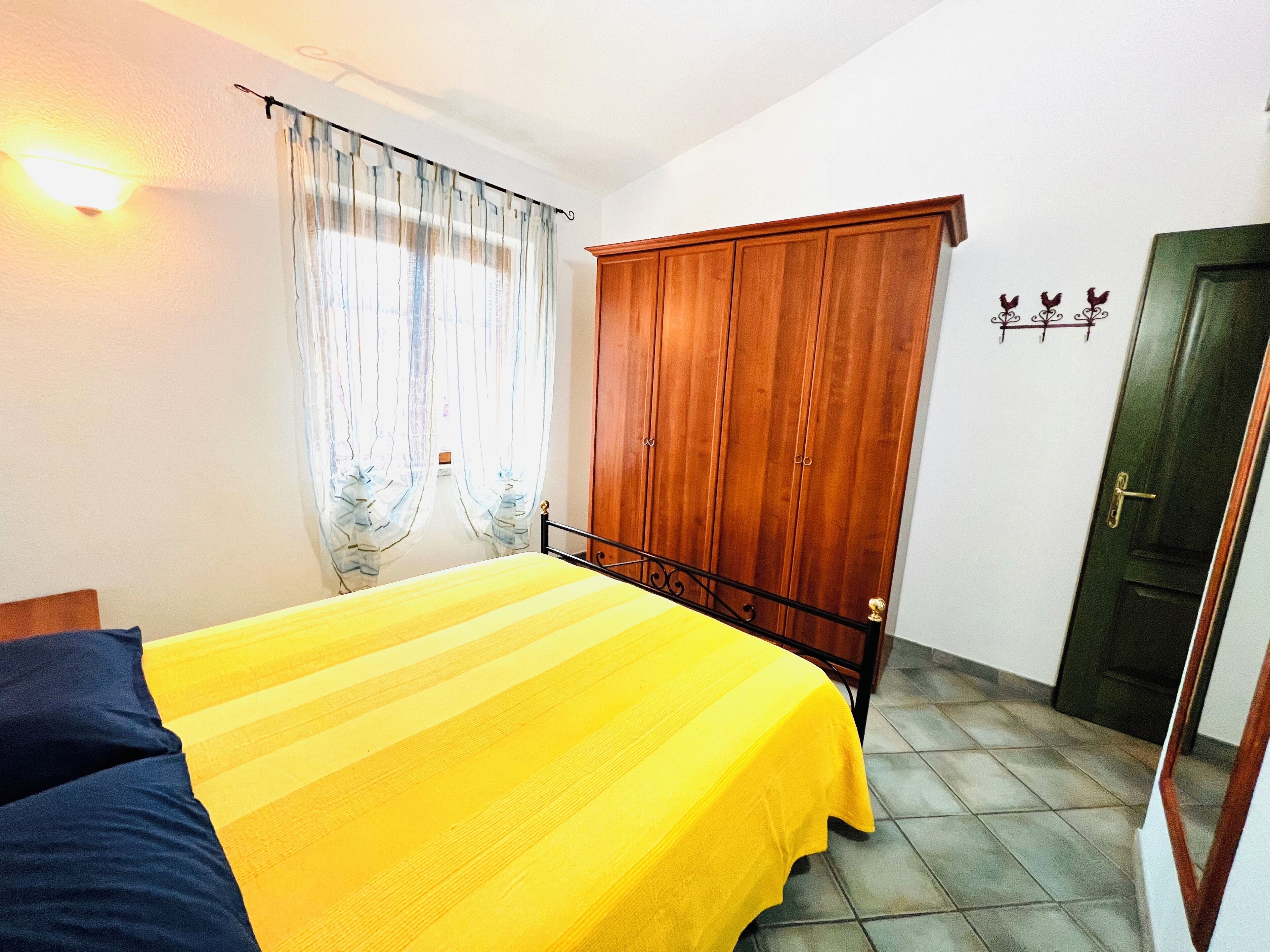 A bedroom with a bed, a wardrobe, and a door.