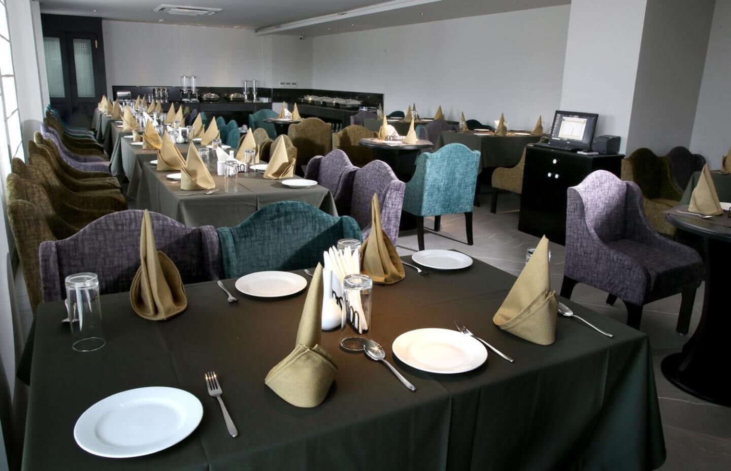 A dining area with tables set for a meal, including plates, cutlery, and napkins.