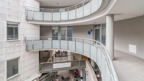 A multi-level atrium with a curved staircase, open seating areas, and a central column. - Luxurious Suites Elegance (Zadar)