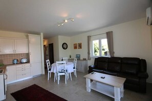 Un espacio habitable compacto con cocina, comedor y sala de estar con sofá y mesa de centro.