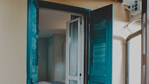 Una habitación con cama, una puerta y una escalera que da a un espacio exterior.