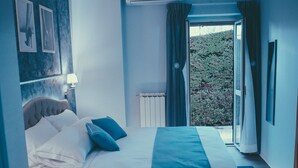 Un dormitorio con una cama, una ventana y vistas al exterior.