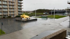 A modern building with a yellow sculpture in the courtyard. - Havenzicht 105 (Nieuwpoort)
