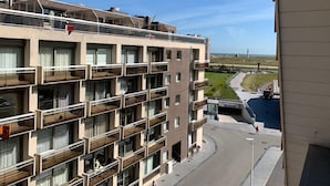 A multi-story hotel with balconies, a view of the beach, and a parking area. - Noorderbries 404 (Nieuwpoort)