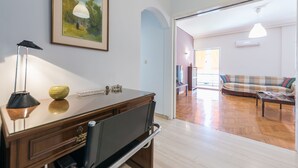 A living room with a wooden coffee table, a sofa, and a TV on a stand. - Comfortable Apartment near City Center (Athens)