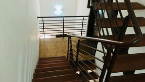 Uma escadaria com corrimão de metal e degraus de madeira.