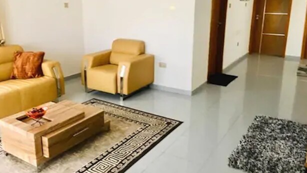 Uma sala de estar moderna com sofá, poltrona e mesa de centro.