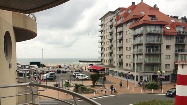 A coastal urban area with a multi-story building, a roundabout, and a view of the sea. - Zeezicht 201 (Nieuwpoort)