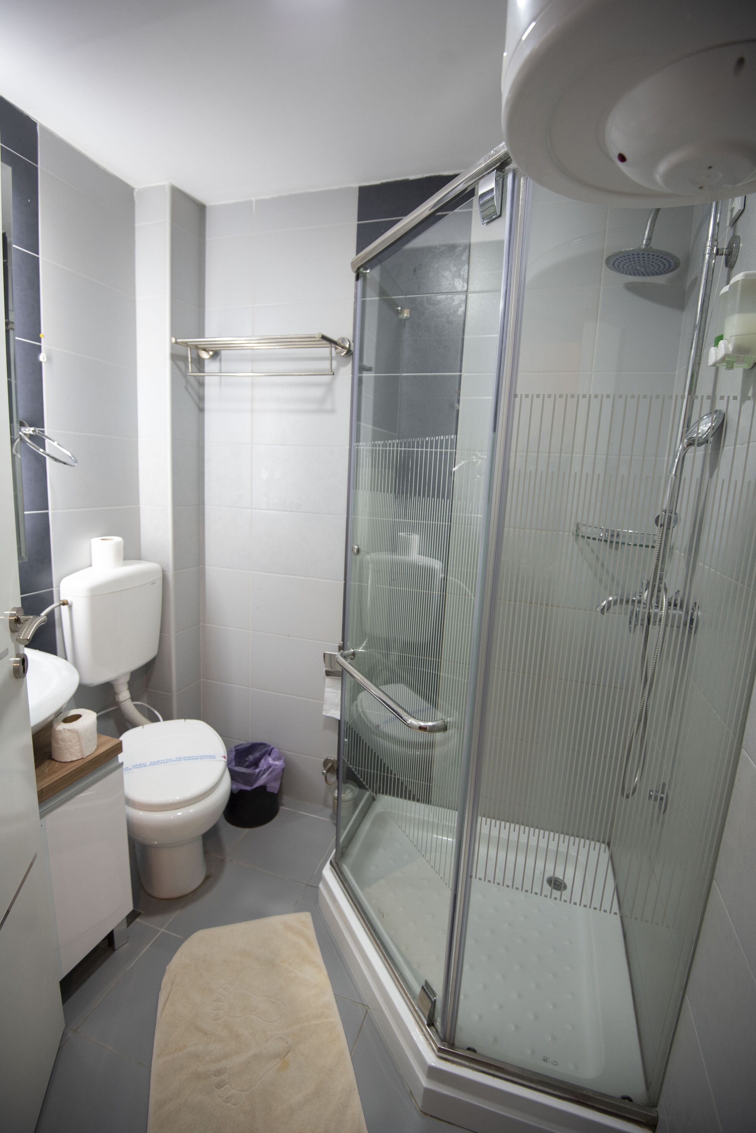 Un bagno moderno con doccia vetrata, un water e un lavandino.