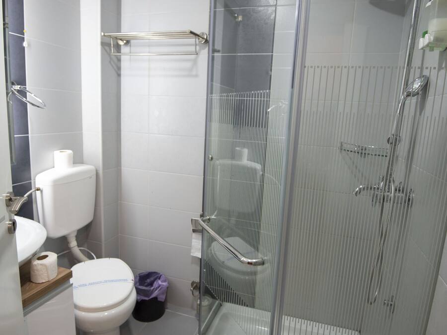 Un bagno moderno con doccia vetrata, un water e un lavandino.