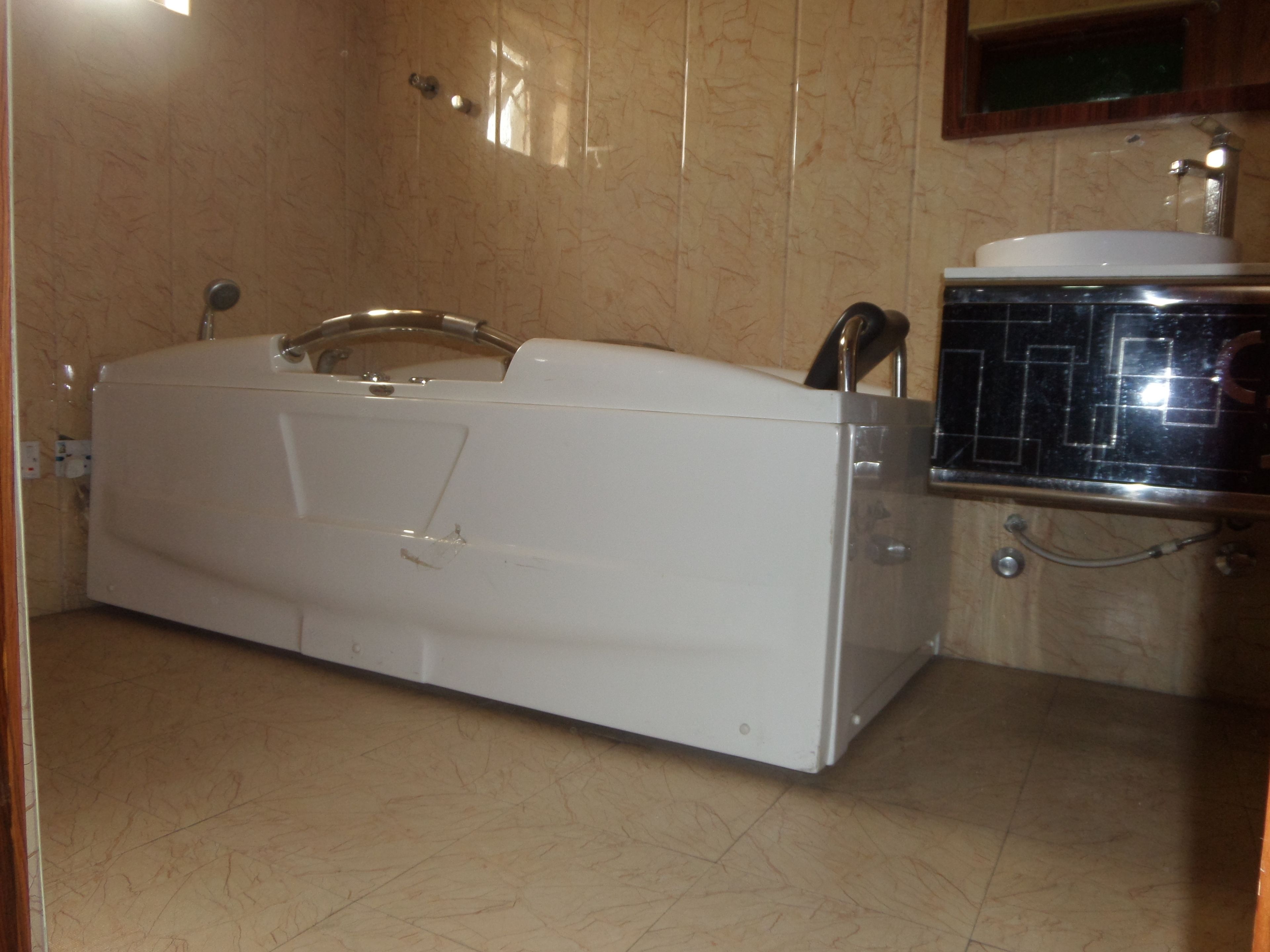 Een badkamer met een witte badkuip, een wastafel en een spiegel.