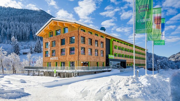 Ein Hotel mit modernem Design, das mehrere Fenster und eine auffällige Beschilderung zeigt.