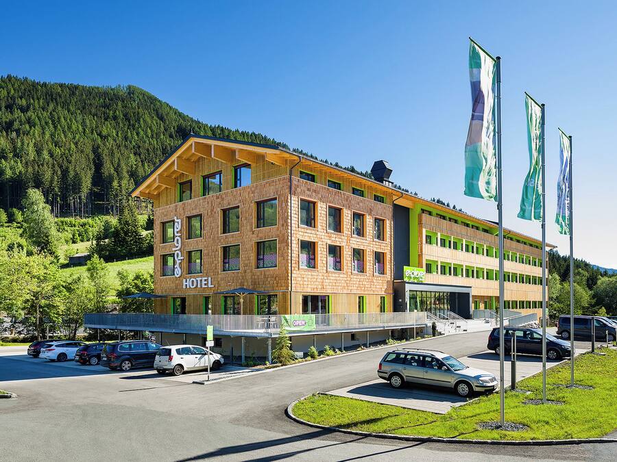 Un hôtel au design moderne, avec plusieurs étages et un parking.