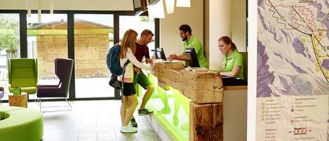 Una recepción con mostrador de madera, un mapa en la pared y un mobiliario moderno.