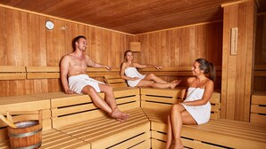 Eine Sauna mit Holzbänken und einem Holzeimer.