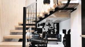 Een modern interieur met een trap, een eetgedeelte en een zithoek.