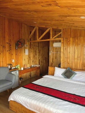 Una camera in legno con un letto, una scrivania e una sedia.
