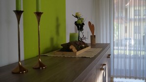 Una mesa de madera con un florero, una vela y un objeto con forma de corazón de madera.
