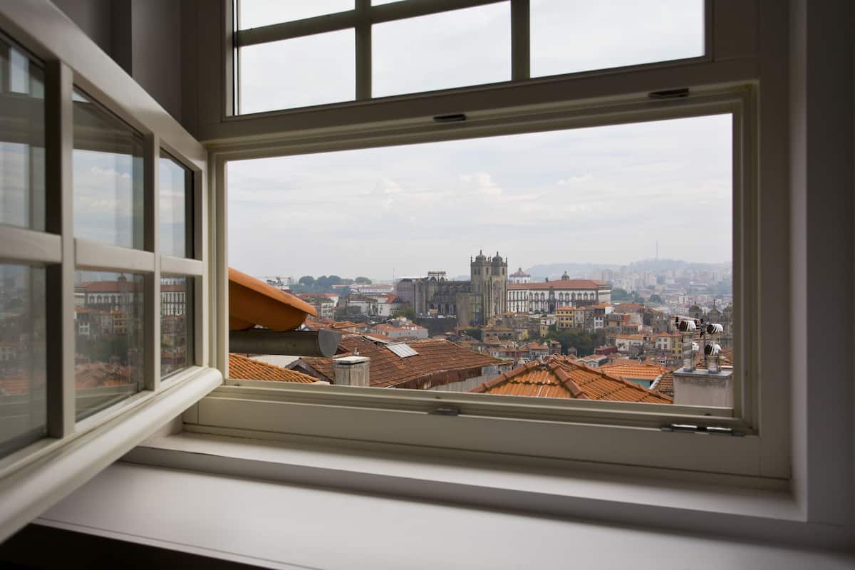 A view from a window overlooking a cityscape with historic buildings and a prominent church.