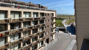 A multi-story hotel with balconies, a view of the beach, and a parking area. - Nautillus 304 (Nieuwpoort)