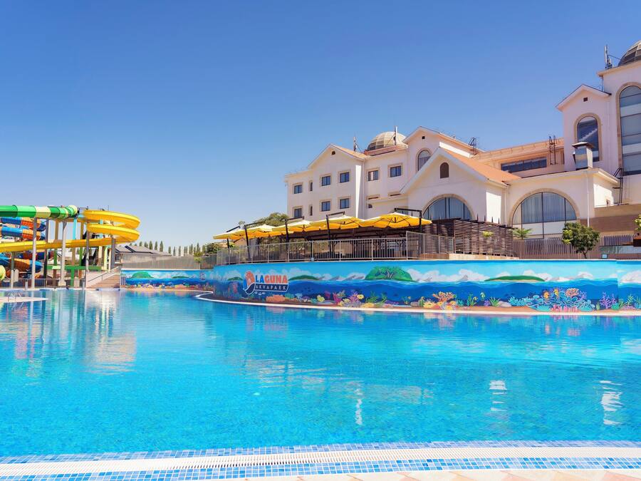 A swimming pool with a water slide and a mural depicting an underwater scene.