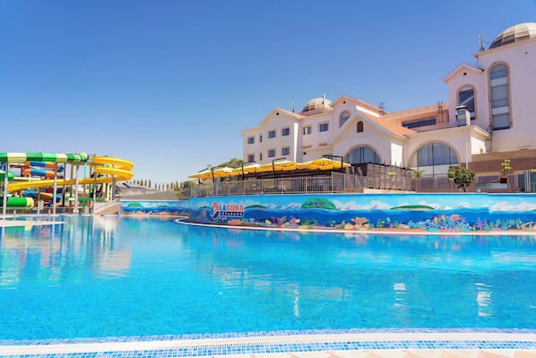 Une piscine avec un toboggan et une fresque représentant un paysage sous-marin.