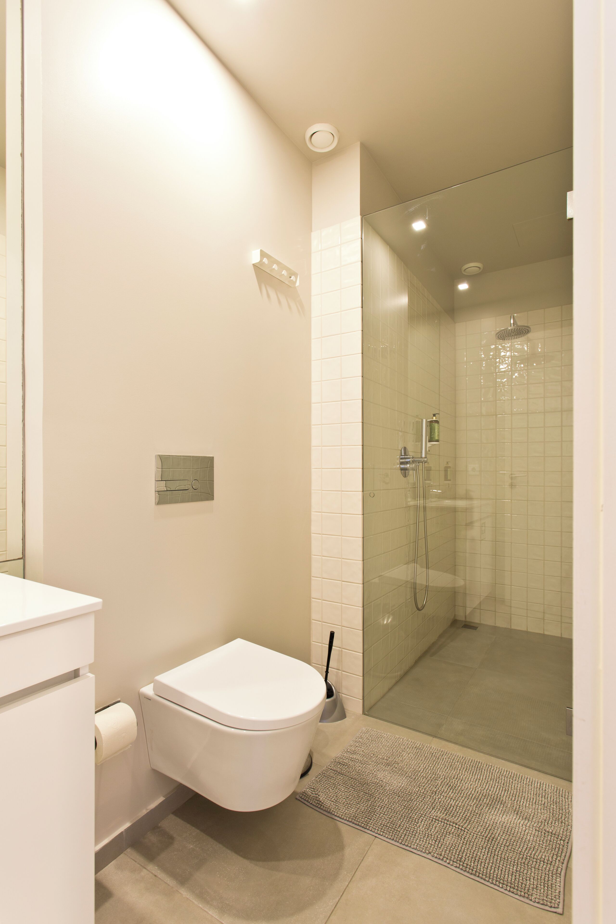 Une salle de bain moderne équipée de toilettes, d’une douche et d’un lavabo.