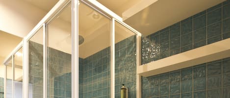 Un baño con ducha de vidrio, inodoro y lavamanos.