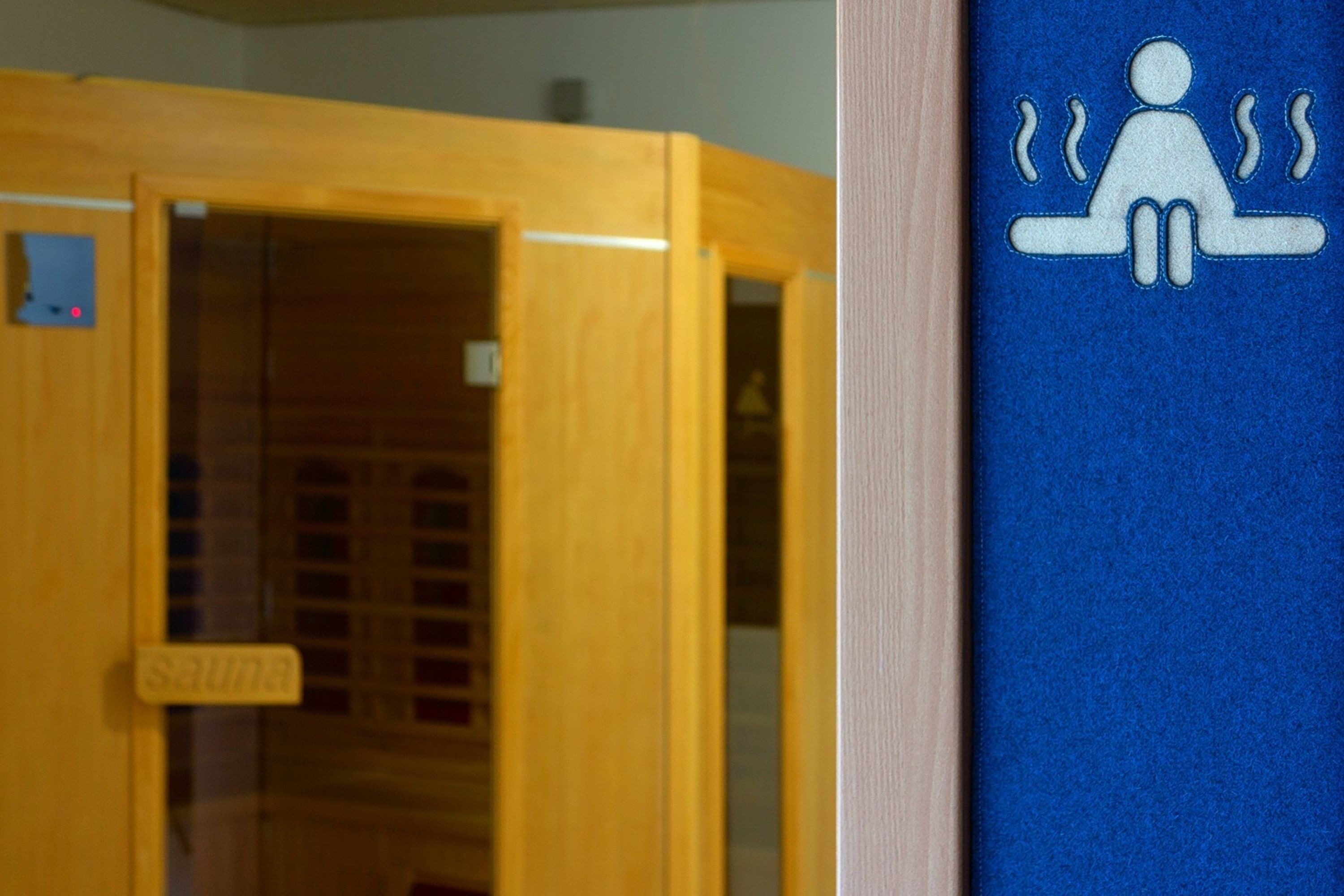 A sauna room with a wooden door and a sign that reads "sauna".