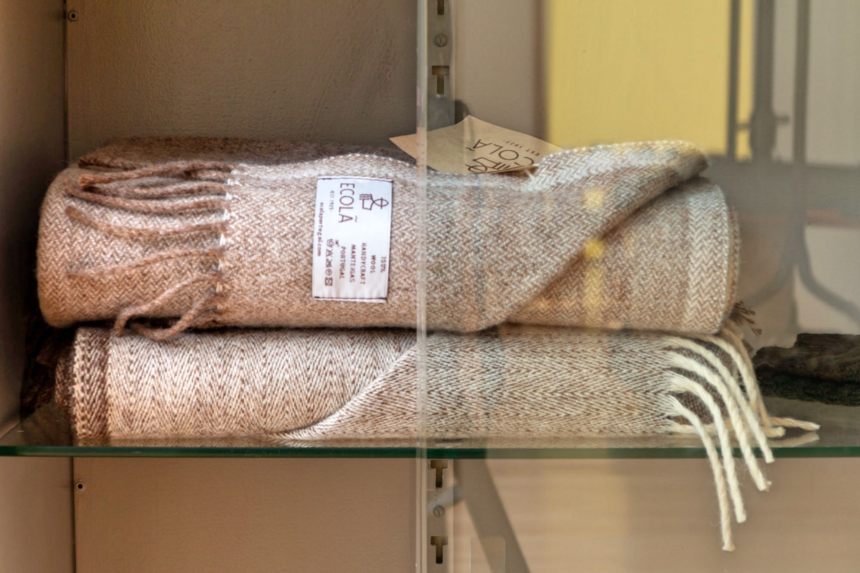 A stack of folded blankets on a shelf.