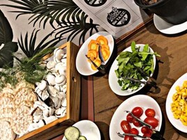 Una mesa de comedor con varios platos, incluyendo champiñones, tomates y una ensalada.