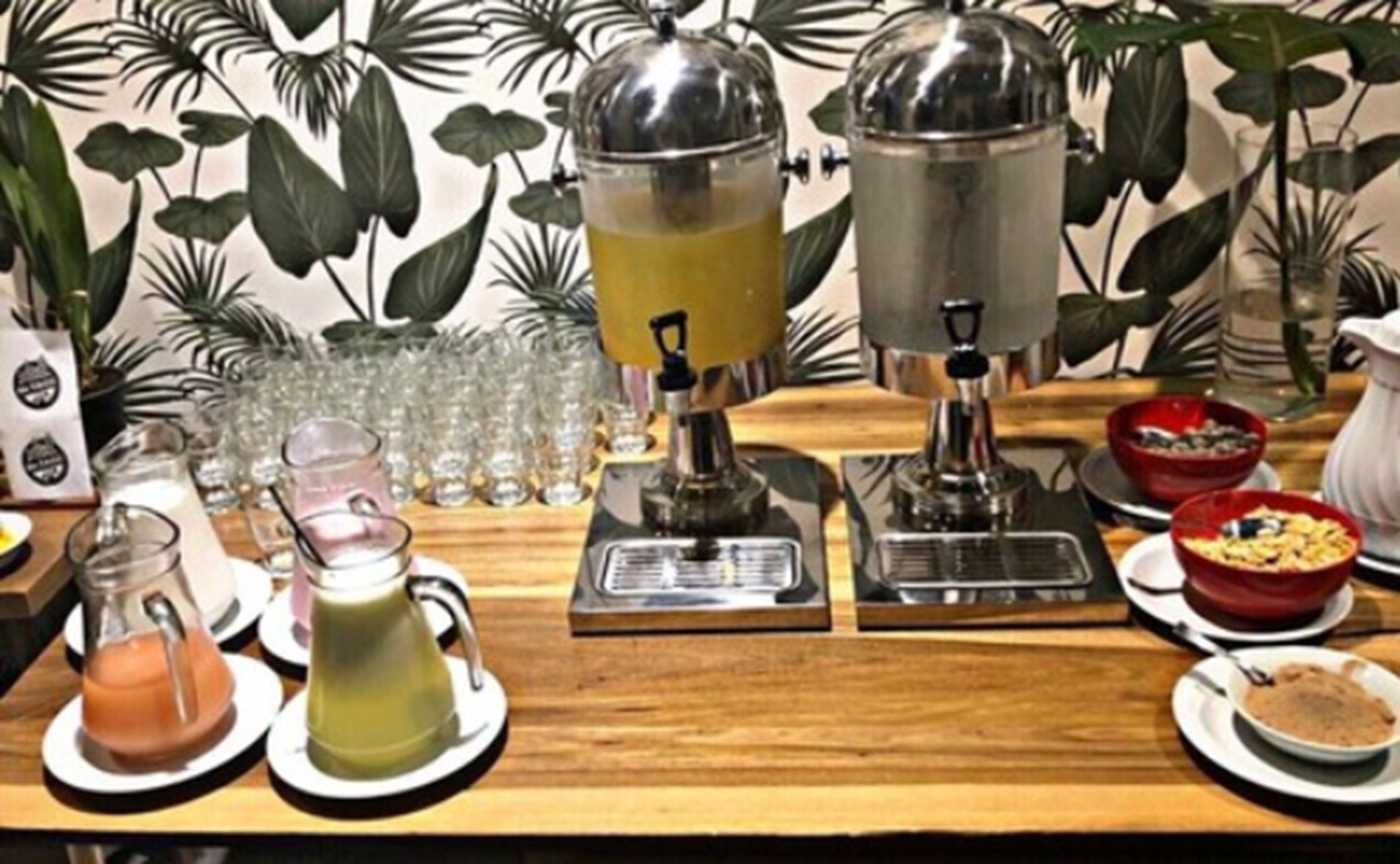Un coin café équipé d’une machine à café, de tasses et d’un pichet en verre.