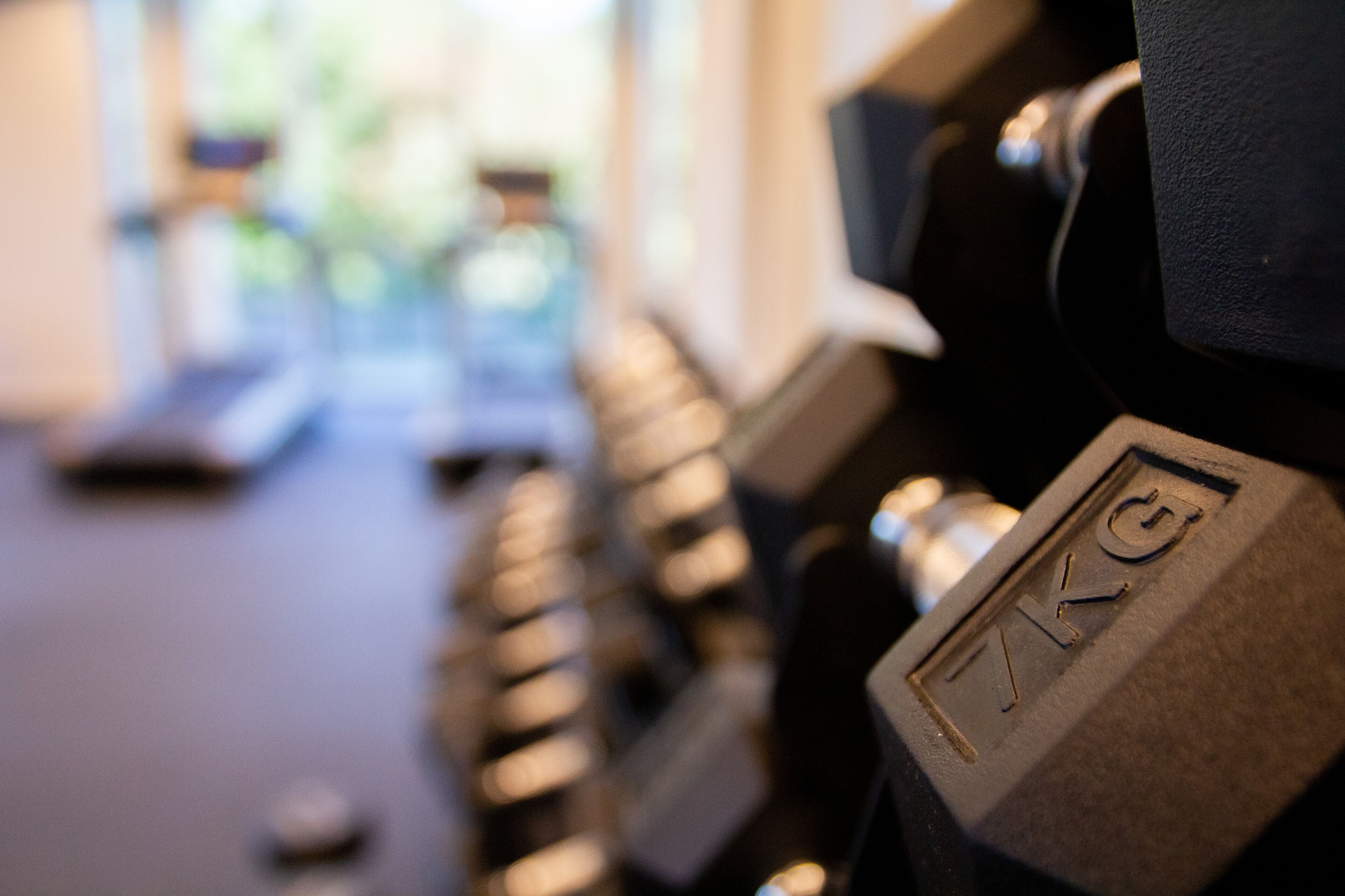 A close-up of a weight stack on a dumbbell with the label "7KG".