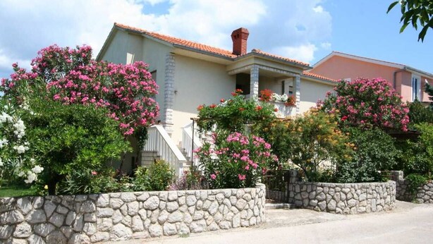 A house with a stone wall, pink flowering bushes, and a clear sky. - Apartment Grskovic G. Setaliste A4 (Silo - island Krk)