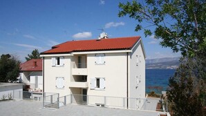 Ein zweistöckiges Gebäude mit rotem Dach, weißen Wänden und einem Balkon.