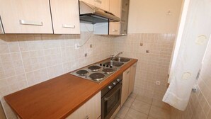 A compact kitchen with a wooden countertop, a stove, an oven, and a sink. - Apartment Dudovic Darko nr 4 (Silo - island Krk)