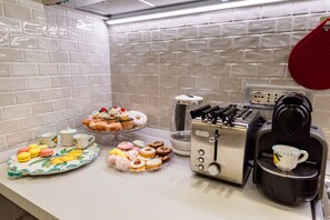 Una encimera de cocina con diversos pasteles y una cafetera.