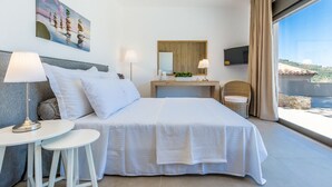 Ein modernes Hotelzimmer mit einem großen Bett, einem kleinen Tisch, einem Sessel, einem Fernseher, einem Nachttisch aus Holz und einem großen Fenster mit Landschaftsblick.