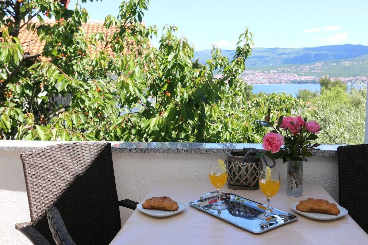 Una mesa con alimentos para el desayuno y vistas a un pueblo y montañas.