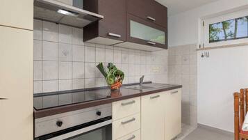 Coffee/tea maker, fridge, cookware/dishes/utensils, dining table