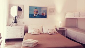 Een hotelkamer met een bed, een dressoir, een spiegel, een schilderij en een stapelbed.