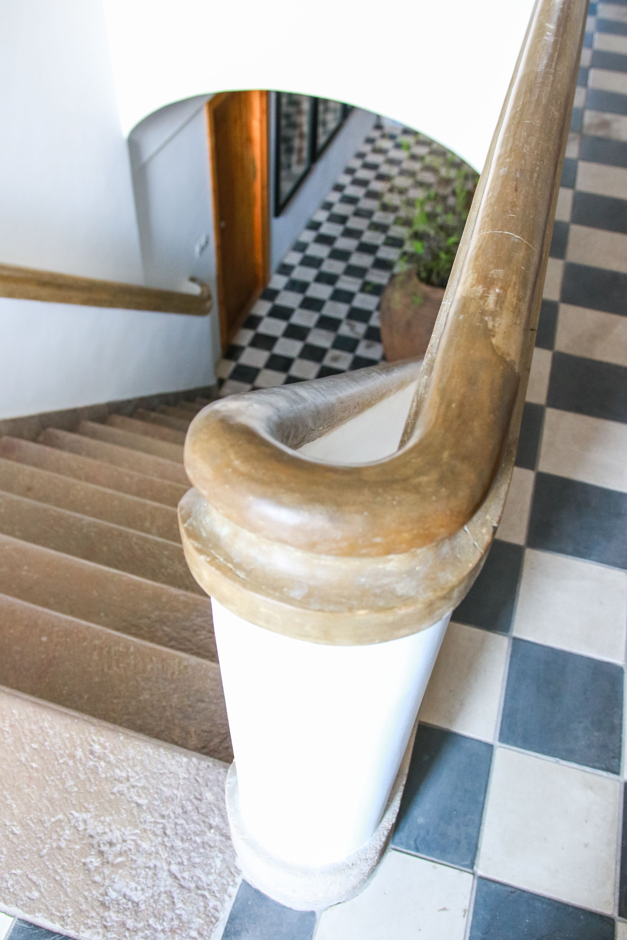 Un escalier avec une rampe en bois et des marches blanches.